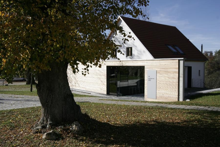 Das Dokumentationszentrum. Davor: Ein alter Baum. Blick auf das Eingangsportal. Bildnachweis: Gedenkstätte Grafeneck Dokumentationszentrum