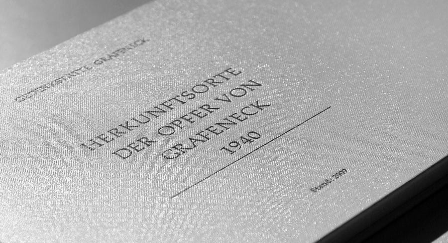 Das Gedenk- und Namensbuch von Grafeneck wurde erstmals 1994 veröffentlicht. Seit 2009 existiert ein zweites Buch. Es enthält die vielen hundert Herkunftsorte der Opfer von Grafeneck 1940. Das Bild zeigt ein helles Buch. Auf dem Umschlag steht "Herkunftsorte der Opfer von Grafeneck 1940. Stand 2009".