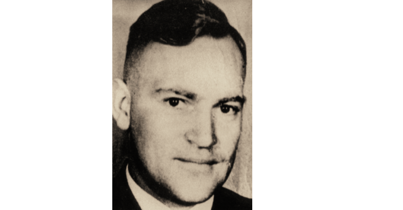 Porträt von Dr. Horst Schumann (1906-1983), ärztlicher Direktor und Tötungsarzt in den T4-Vernichtungsstätten Grafeneck 1939/40 und Sonnenstein in Pirna 1940/41; Lagerarzt in Auschwitz-Birkenau. Das Bild zeigt einen Mann mit dunklen Augen und dunklen Haaren, die er als Seitenscheitel trägt. Er lächelt leicht. Bildnachweis: Hessisches Hauptstaatsarchiv Wiesbaden Porträt von Dr. Horst Schumann (1906-1983), ärztlicher Direktor und Tötungsarzt in den T4-Vernichtungsstätten Grafeneck 1939/40 und Sonnenstein in Pirna 1940/41; Lagerarzt in Auschwitz-Birkenau. Das Bild zeigt einen Mann mit dunklen Augen und dunklen Haaren, die er als Seitenscheitel trägt. Er lächelt leicht.